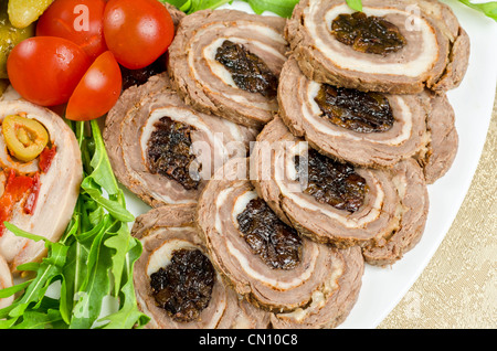 Cutting meat tenderloin with prune with lettuce, tomatoes and Ruccola Stock Photo