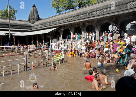 Hindu pilgrims bathing in the sacred  water reservoir of Kushavarta (the source of the Godavari river). Trimbakeshwar. India Stock Photo