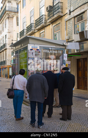 Men reading newspapers on wall of a kiosk Baixa district Lisbon Portugal Europe Stock Photo