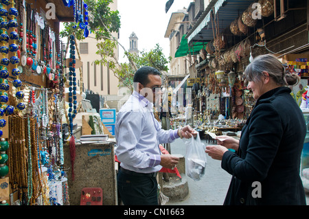 Foreign tourist buying souvenirs from Shopkeeper in Khan El Khalili Cairo Egypt Stock Photo