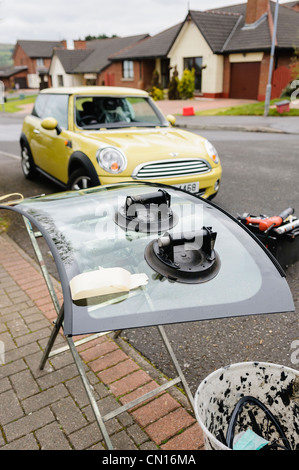 A new windscreen about to be fitted to a yellow Mini Stock Photo