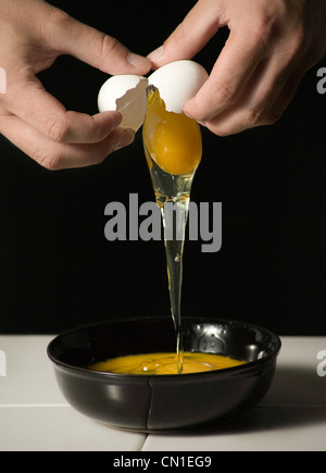 Person Cracking Egg in Bowl Stock Photo