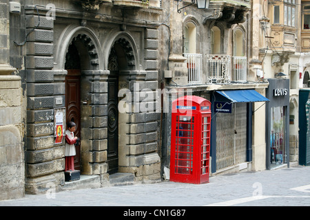 Red English telephone box in the street in Valletta, Malta Stock Photo