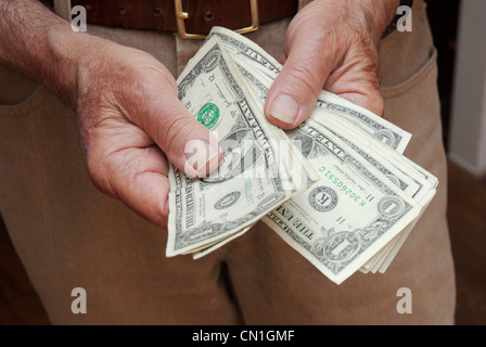 Older Man’s Hands Holding Dollar Bills II Stock Photo