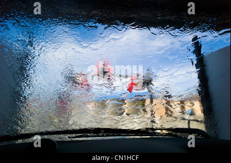 View through the windshield of an automobile in an automated car wash. Stock Photo