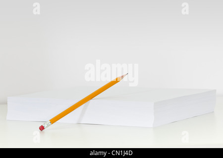 Pencil Leaning Against Stack of White Paper Stock Photo