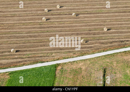 Aerial landscape shot from balloon flying over field with hay bales Stock Photo