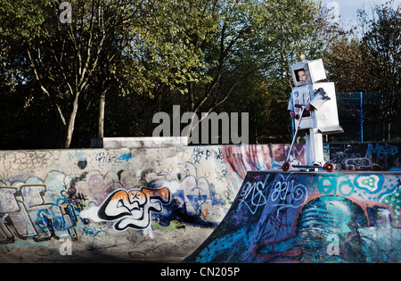 Boy dressed as robot in skate park Stock Photo