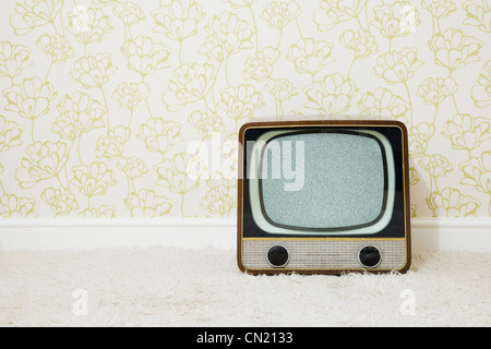 Retro television in room with patterned wallpaper Stock Photo