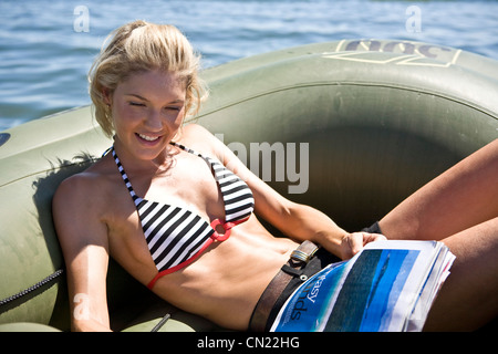 Smiling Young Woman Relaxing in Dinghy Stock Photo