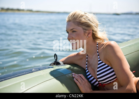 Smiling Young Woman Relaxing in Dinghy Stock Photo