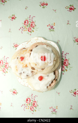 Three iced currant buns on plate Stock Photo