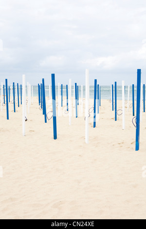 Beach umbrella poles on sandy beach Stock Photo