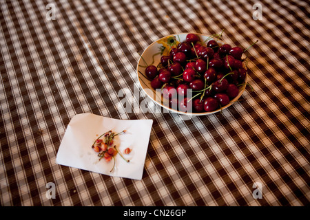 Bowl of cherries on checked tablecloth Stock Photo