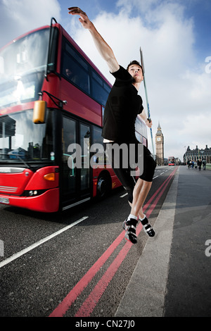 Javelin thrower on road with bus, London, England Stock Photo