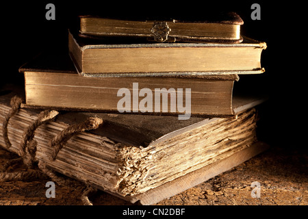 Small stack of antique books in weathered grungy state and gold edged Stock Photo