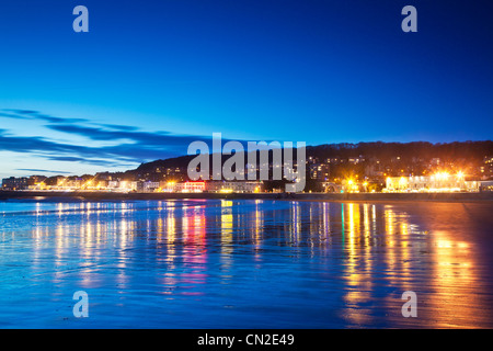 Twilight over Weston-Super-Mare, Somerset, England, UK with the lights of the town reflected in the wet sand at high tide. Stock Photo