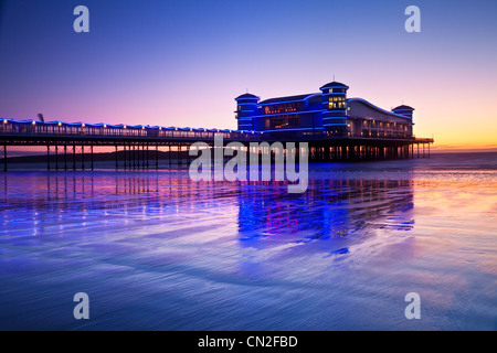 Twilight over the Grand Pier at Weston-Super-Mare, Somerset, England, UK reflected in the wet sand of the beach at high tide. Stock Photo