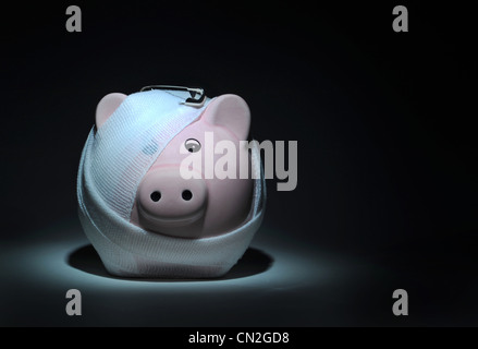 BANDAGED INJURED PIGGYBANK WITH SAFETY PIN RE SAVINGS THE ECONOMY FINANCIAL CRISIS CREDIT CRUNCH INTEREST RATES MARKETS CASH UK Stock Photo