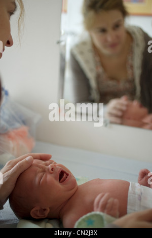 Newborn baby boy crying, mother touching head Stock Photo