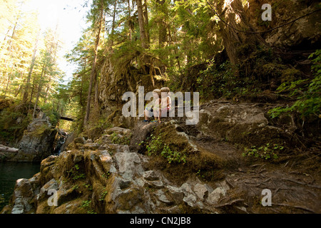 Two boys sitting on rocks in forest Stock Photo