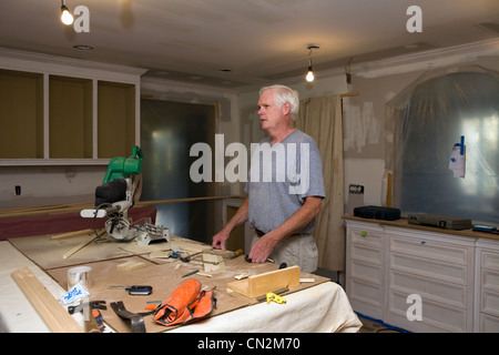Senior man doing DIY in kitchen Stock Photo