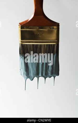 Paintbrush dripping with blue paint Stock Photo