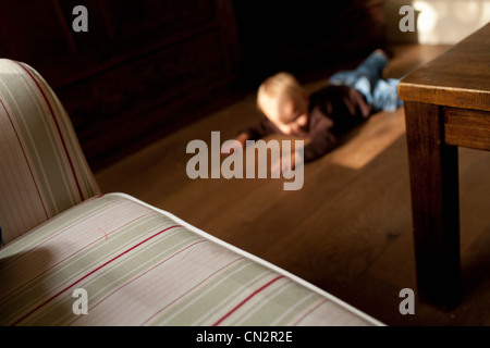Toddler boy lying on floor Stock Photo