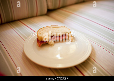 Half eaten sandwich on plate Stock Photo