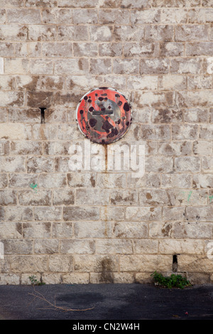 Rusty no parking sign on stone wall Stock Photo