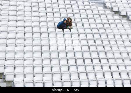 Couple sitting on stadium seats Stock Photo