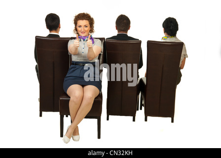 Successful woman sitting on chair out of the crowd and giving thumbs Stock Photo