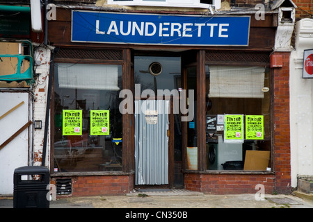 Abandoned and boarded up old / closed shut-up / shuttered derelict laundry / launderette shop in Twickenham. London. UK. Stock Photo