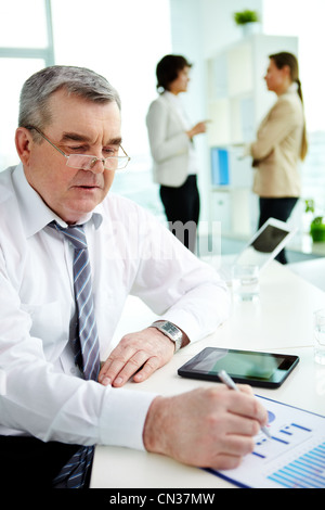 Mature businessman checking the business data presented in graphs Stock Photo