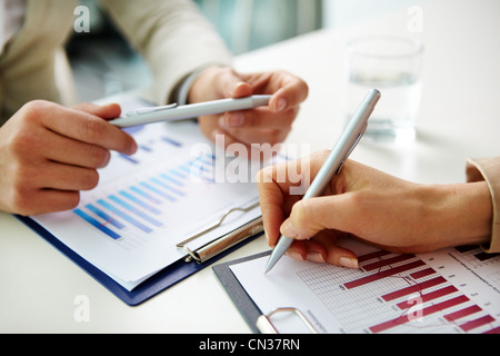 Two female business workers discussing graphs at office Stock Photo