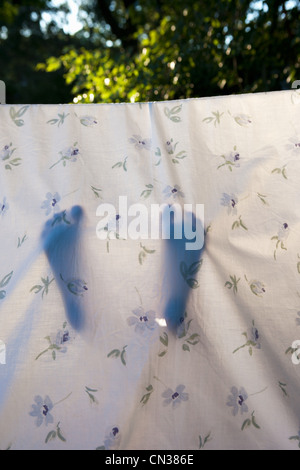 Child's feet in homemade den made from sheet Stock Photo
