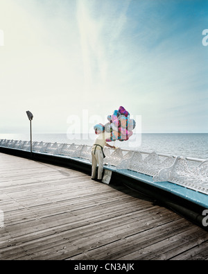 Man selling helium balloons at seaside Stock Photo