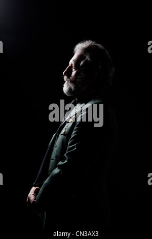 Senior man wearing military uniform against black background Stock Photo