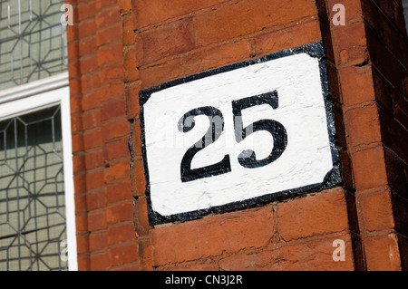 ‘ 25 ‘ house number painted on a red brick wall Stock Photo