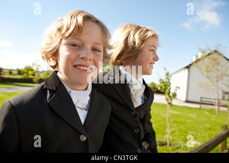 Boys wearing horse riding clothes, smiling Stock Photo