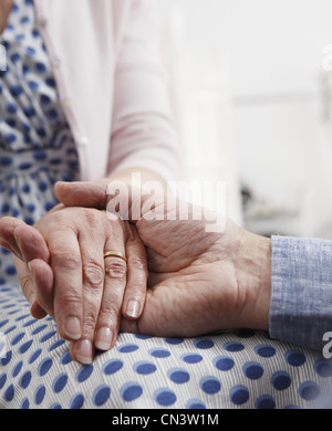 Senior couple holding hands, close up