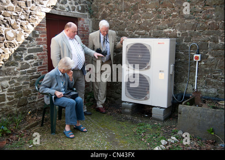 people looking at a working Air source heat pump unit at the National Trust, Llanerchaeron, Ceredigion, Wales UK Stock Photo