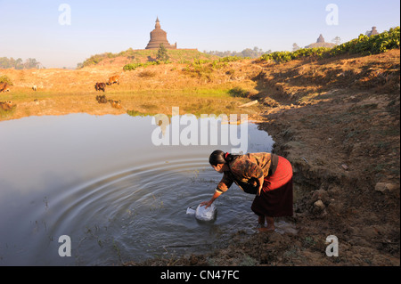 Myanmar (Burma), Rakhine State (Arakan), Mrauk U, young woman taking drinking water in a pond Stock Photo