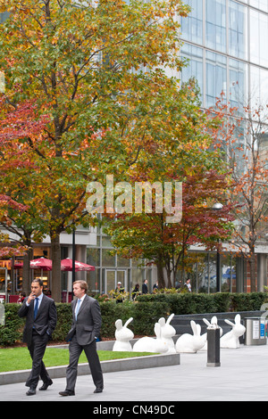 United Kingdom, London, Old Spitafields Market, Bishops Square, business men walking by rabbits sculpture dating 2009 called Stock Photo