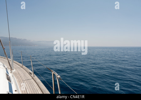 View of the side of a yacht and the Sardinian coast Stock Photo