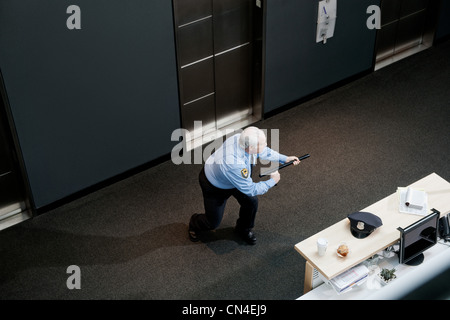 Security guard brandishing baton in office Stock Photo