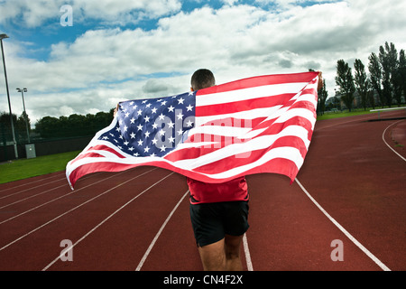 Sprinter running with US flag on sportstrack Stock Photo