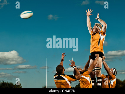 Rugby player leaping up to catch ball Stock Photo - Alamy