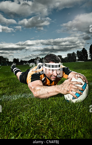 Rugby player scoring on pitch Stock Photo