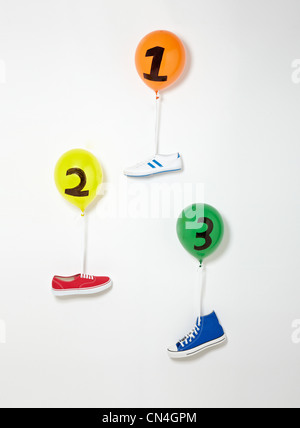 Trainers floating upward suspended by balloons Stock Photo